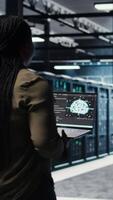 Vertical Programmer doing data center automation using AI software tools, enhancing workflow. Server room IT expert implements artificial intelligence driven predictive maintenance systems, camera A video