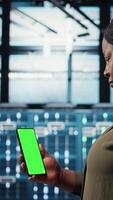 vertikal chef använder sig av app på krom nyckel telefon till kolla upp server bruka energi konsumtion. data Centrum systemet administratör använder sig av Ansökan på grön skärm smartphone till kolla upp kraft användande nivåer, kamera en video