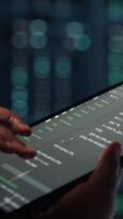 Vertical Close up of programmer in data center using tablet to implement advanced power management solutions. Worker using device to oversee server hub, reducing energy consumption video
