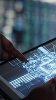 Vertical Close up of data center technician doing AI data analysis on tablet to upgrade infrastructure. Server room employee using device to manage storage systems for machine learning training datasets video