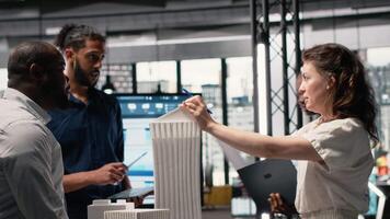 diverso equipo de desarrolladores compartiendo construcción detalles en un instrucciones sesión, urbano desarrollo visión utilizando avanzado arquitectónico software y 3d modelos para un moderno alojamiento proyecto. cámara b. video