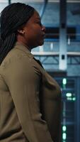 vertikal systemet administratör arbetssätt i data Centrum till optimera nätverk infrastruktur. afrikansk amerikan kvinna i i server bruka diagnos och lösa hårdvara felfunktioner använder sig av enhet video