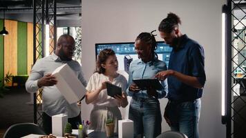 diverso equipo de real inmuebles desarrolladores utilizando 3d modelos en un moderno oficina, arquitectónico software ayuda planificación un sostenible residencial proyecto enfocado en urbano desarrollo. cámara una. video