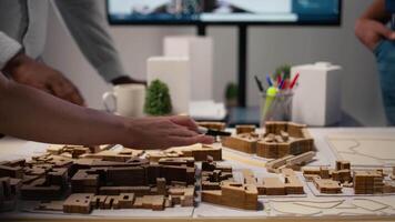 stänga upp av urban utvecklare som visar bemästra planen för bostads- layout projekt, använder sig av 3d modeller på tabell till närvarande aning av en smart stad. webbplats förberedelse för infrastruktur tillväxt. kamera a. video