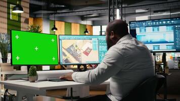 schwarz Ingenieur funktioniert auf Fußboden planen Design mit ein Attrappe, Lehrmodell, Simulation Anzeige, Eigentum Entwicklung und Konstruktion Planung. Zoneneinteilung Vorschriften und Wohn Blaupausen Hilfe mit städtisch Wachstum. Kamera a. video