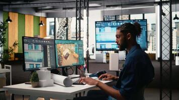 mitten östra manlig utvecklare skapande fast egendom layout med möbel och Övrig strukturera detaljer, interiör design på dator. arbetssätt på sanering för en bostads- konstruktion. kamera a. video