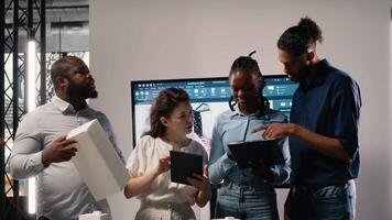 diverso equipo de real inmuebles desarrolladores utilizando 3d modelos en un moderno oficina, arquitectónico software ayuda planificación un sostenible residencial proyecto enfocado en urbano desarrollo. cámara b. video