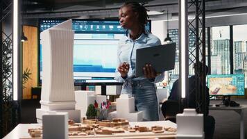 afrikansk amerikan kvinna utvärdera 3d byggnad modell för mått, skapande konstruktion ritningar för layout och framställning dokumentation för godkännande på en bostads- projekt. kamera a. video