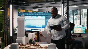African american property developer focusing on land acquisition and construction planning, reviewing project layout that align with smart city and infrastructure growth. Innovation hub. Camera A. video