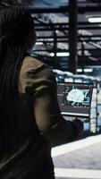 Vertical Data center engineer using deep learning on laptop to optimize operations efficiency. IT expert working in server room with specialized hardware accelerating complex AI calculations, camera A video