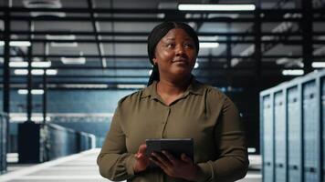 datos centrar software desarrollador monitores datos centrar métrica en tableta a mejorar Operacional eficacia. mujer en servidor habitación utilizando aplicación dispositivo analítica a predecir actuación, cámara si video