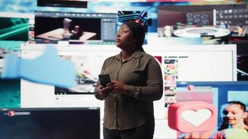 kvinna använder sig av smartphone omgiven förbi kurerad rekommendationer medan bläddring strömning tjänster. person njuter fri tid bläddring favorit uppkopplad clips på telefon, kamera en video