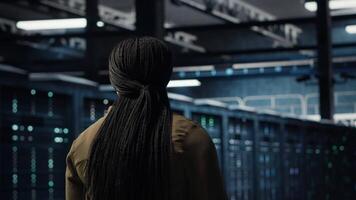 Programmierer beaufsichtigen hoch Technik Server Bauernhof, gewährleisten Beachtung mit Industrie Normen. Daten Center es Fachmann führt Sicherheit Audits zu schützen gegen Cyber Bedrohungen und Glitches, Kamera b video