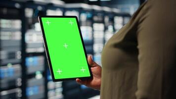 ingegnere a opera utilizzando isolato schermo tavoletta nel dati centro per dai un'occhiata hardware per sistema stabilità. lavoratore utilizzando croma chiave dispositivo per sorvegliare server azienda agricola e configure infrastruttura, telecamera B video