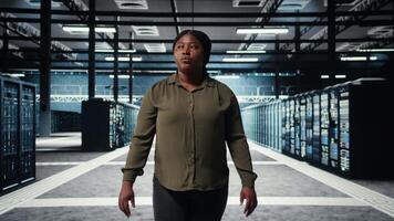 software desarrollador caminando en datos centro, comprobación hardware para sistema estabilidad. sistema administrador supervisando servidor granja habitación, supervisión infraestructura plataformas, cámara un video