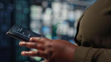 Programmer in data center using tablet to upgrade servers for increase in clients workload capacity. IT specialist in server farm configuring hardware rigs, improving data processing speed, camera B video