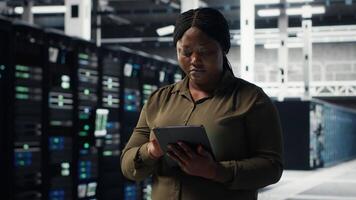 técnico utilizando tableta en datos centro, integrando nuevo tecnologías y sistemas empleado utilizando dispositivo a supervisar servidor centro, asegurando conformidad con industria estándares, cámara si video