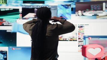 mujer abraza abundancia de contenido desplegado en digital pared panel, explorador entretenimiento canales usuario asombrado por inmersivo transmisión plataforma entregando sin escalas vídeos, cámara un video