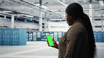 arbetstagare använder sig av app på attrapp telefon till kolla upp server nav energi konsumtion. administration använder sig av grön skärm smartphone i data Centrum till motta instruktioner på genomförande kraft förvaltning lösningar. kamera en video