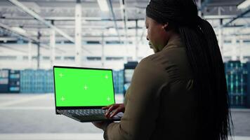 computadora científico a trabajo utilizando verde pantalla ordenador portátil en datos centrar a cheque hardware para sistema estabilidad. gerente utilizando Bosquejo cuaderno a supervisar servidor granja engranaje, cámara un video