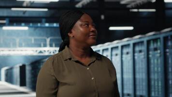 handledare i data Centrum övervaka stor skala den Utrustning till upprätthålla sömlös operationer. den expert- gående mellan server rum rader, håller på med nätverk förvaltning för ökade upptid, kamera b video