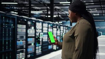 anställd använder sig av app på attrapp mobil telefon till kolla upp server nav energi konsumtion. data Centrum ingenjör använder sig av Ansökan på isolerat skärm smartphone till kolla upp kraft användande nivåer, kamera en video