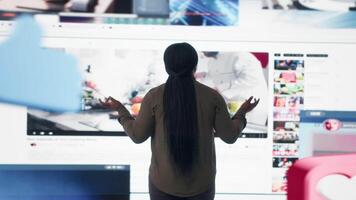 utilisateur interagir avec tendance en ligne vidéos alimentation sur numérique plates-formes. femme regards à virtuel mur avec global canaux diffusion tableau de bord avec viral clips playlist, caméra b video
