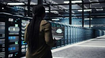 Programmer doing data center automation using AI software tools, enhancing workflow. Server room IT expert implements artificial intelligence driven predictive maintenance systems, camera A video