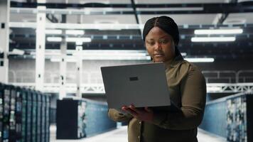 Les données centre lieu de travail programmeur en utilisant portable à coordonner déploiement de Nouveau serveur architecture. serveur pièce ouvrier en utilisant carnet à faire sortir de la cyber-sécurité cadre, protéger données, caméra b video