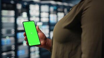 anställd använder sig av app på attrapp mobil telefon till kolla upp server nav energi konsumtion. data Centrum ingenjör använder sig av Ansökan på isolerat skärm smartphone till kolla upp kraft användande nivåer, kamera b video