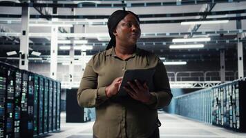 técnico utilizando tableta en datos centro, integrando nuevo tecnologías y sistemas empleado utilizando dispositivo a supervisar servidor centro, asegurando conformidad con industria estándares, cámara un video