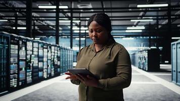 datos centrar software desarrollador monitores datos centrar métrica en tableta a mejorar Operacional eficacia. mujer en servidor habitación utilizando aplicación dispositivo analítica a predecir actuación, cámara un video