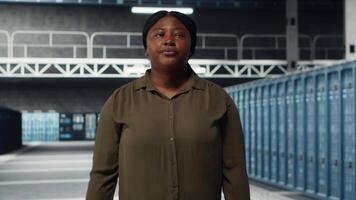 beheerder wandelen in gegevens centrum, toezicht houden op groot schaal het infrastructuur naar in stand houden naadloos activiteiten. server boerderij werknemer aan het doen netwerk beheer voor is gestegen beschikbaarheid, camera b video