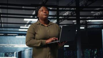 superviseur dans Les données centre en utilisant portable à coordonner déploiement de Nouveau serveur architecture. serveur ferme il spécialiste en utilisant carnet à faire sortir de la cyber-sécurité cadre, protéger données, caméra b video