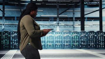 sorridente dati centro tecnico utilizzando tavoletta per gestire Software aggiornamenti per sistema stabilità. ottimista esso esperto nel server camera configurazione infrastruttura con dispositivo per ottimale prestazione, telecamera un' video