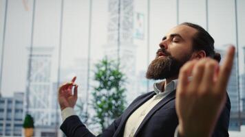 CEO inclina-se costas dentro dele escritório cadeira noivando dentro uma guiado meditação sessão com branco barulho, usando uma meditação aplicativo. comprometimento para atenção para carreira sucesso e mental clareza. Câmera uma. video
