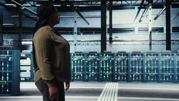 tekniker i data Centrum övervaka stor skala den redskap till upprätthålla sömlös operationer. den professionell gående i server nav, håller på med nätverk förvaltning för ökade upptid, kamera en video