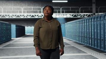 ingegnere a piedi nel dati centro, controllo hardware per sistema stabilità. dipendente supervisione server azienda agricola impianti di perforazione, configurazione infrastruttura per ottimizzare prestazione, telecamera B video