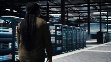 Programmierer beaufsichtigen hoch Technik Server Bauernhof, gewährleisten Beachtung mit Industrie Normen. Daten Center es Fachmann führt Sicherheit Audits zu schützen gegen Cyber Bedrohungen und Glitches, Kamera ein video