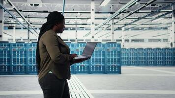 sonriente datos centrar ingeniero satisfecho después minimizando falta del tiempo utilizando desastre recuperación planes en ordenador portátil. contento servidor granja eso experto satisfecho después mejorando datos proteccion protocolos, cámara un video