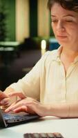 Vertical Close up of woman spends the night transcribing key points, typing on her laptop. Creating a summary, proofreading numbers and designing a strategy to align with company targets. Camera A. video