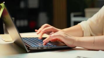 stänga upp av kvinna spenderar de natt transkribering nyckel poäng, skriver på henne bärbar dator. skapande en sammanfattning, korrekturläsning tal och design en strategi till justera med företag mål. kamera b. video