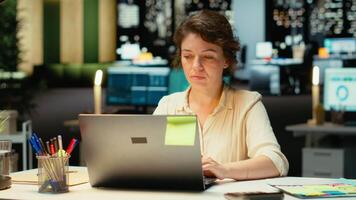 anställd engagerad i forska och dokumentera tal för Rapportera uppdateringar för företag företag, natt tid arbete i en mörk kontor. fokusera på mål och projekt utveckling. kamera b. video