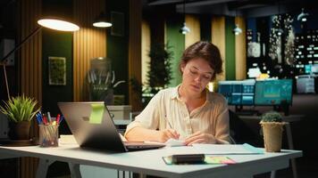 mujer de negocios hace Error en transcribiendo Finanzas actualizaciones en computadora portátil, desgarro arriba el papel sábana y reiniciando. descontento impaciente trabajador falto a terminar Tareas para el noche. cámara una. video