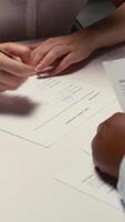 Vertical Close up of job seeker signing a work contract after successful interview, applicant reviewing legal terms of employment before signed agreement. Onboarding process for new beginning. Camera A. video