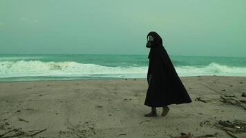 A Man In A Cloak And Gas Mask Walks On A Radiation Poisoned Beach Outdoor video