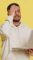 missnöjd indisk man använda sig av bärbar dator anteckningsbok skriver bläddring arbetssätt, förlorar passande överraskad förbi lotteri dålig resultat Nyheter förmögenhet förlorat spel misslyckas dator virus. arab kille isolerat på gul bakgrund video