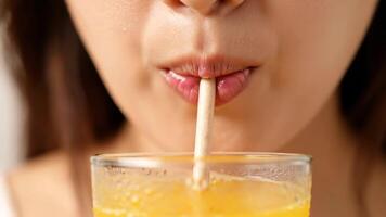 Frau Getränke Orange Saft mit Stroh schließen oben während das Morgen im ein Küche video