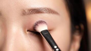 hoe naar van toepassing zijn oogschaduw een detailopname zelfstudie van een vrouw gebruik makend van een borstel Aan haar ooglid in een huis instelling video