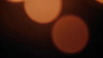 bokeh cerchi scintillante su buio sfondo la creazione di astratto arancia colore splendore video